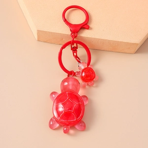 Close-up of dual red resin turtle keychains with glossy finish and lobster clasp