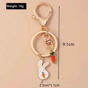 Detailed view of a golden bunny keychain with weight and dimension specs on peach background