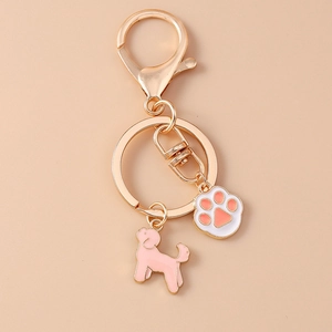 Détails du porte-clés doré avec breloques en émail de chien rose et patte mignonne
