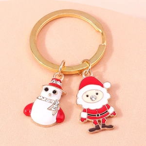 Detailed close-up of Christmas snowman and Santa Claus enamel charms with rhinestones