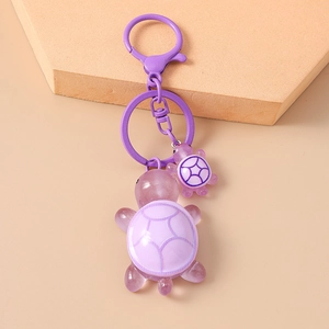 Detail of purple resin turtle keychain featuring large and small pendants with metal clip