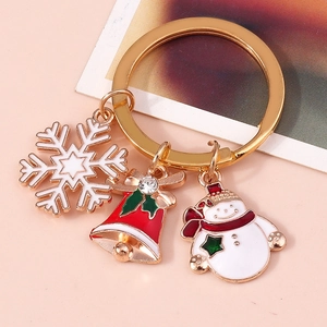 Detail of Christmas keychain featuring alloy snowman, red bell, and white snowflake charms
