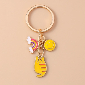 Detail showing cartoon cat, rainbow and smiley face charms on a golden metal keychain