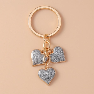 Detailed macro view of the sparkling heart pendants on a golden metallic keychain ring