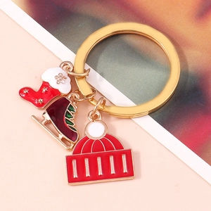 Close-up of Christmas keychain with red enamel stocking, ice skate and knit hat charms