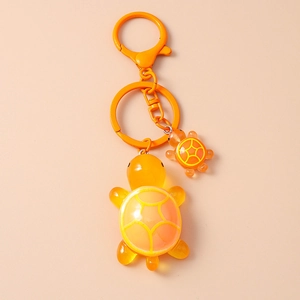 Detail of cute resin turtle keychain with large and small pendants in vibrant orange color