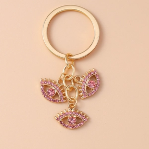 Detailansicht goldener Teufelsauge-Anhänger mit rosa Strasssteinen am Schlüsselanhänger