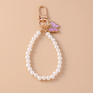 Dettaglio del portachiavi di perle con farfalla in smalto viola e piccoli strass