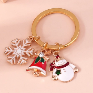 Close-up of Christmas keychain with gold snowflake, red bell, and cute snowman pendants