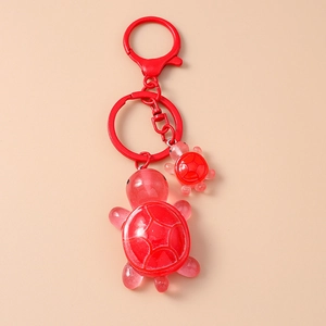Close-up of cute red resin mother and child turtle keychain with glitter details