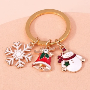 Close-up of Christmas keychain with gold ring, snowflake, bell, and snowman pendants