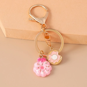 Close-up of golden lobster clasp with 3D pink resin donut and mini alloy charms