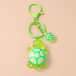 Close-up of mother and baby turtle keychain with translucent green resin and metal clip