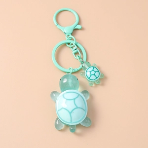 Detail of mint green resin mother and baby turtle keychain with matte hardware