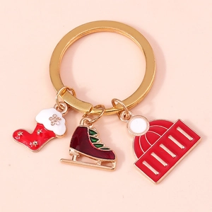 Close-up of Christmas keychain with enamel charms of a red stocking, ice skate and knit hat