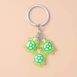 Gros plan de pendentifs tortue en résine verte translucide avec texture de carapace sur porte-clés