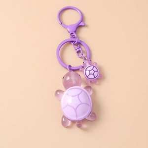 Detail of purple resin turtle keychain featuring dual pendants and a matching lobster clasp