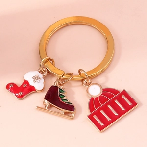 Close-up of Christmas keychain with gold ring, red stocking, ice skate and winter hat charms