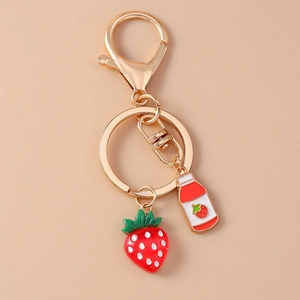 Detail of strawberry charm keychain with gold lobster clasp and miniature drink bottle