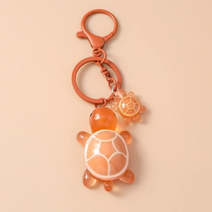 Detail of orange resin turtle keychains with geometric patterns and lobster clasp