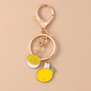Detailed macro of a cute lemon fruit keychain with yellow enamel charms and golden clasp