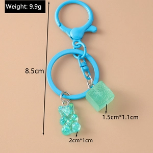 Detailed view of teal gummy bear keychain with dimensions 2x1cm on pink background