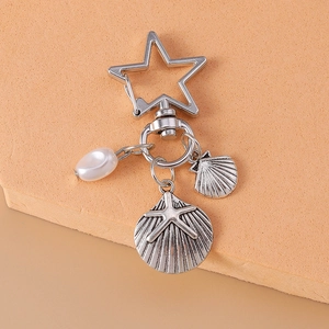 Starfish and shell keychain detail with white pearl on a warm background decoration