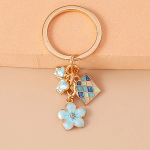 Portachiavi con fiore blu e fiocco con ciondolo a rombi su anello dorato per borsa