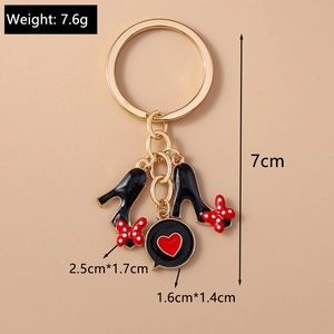Détail macro du porte-clés escarpins avec nœud à pois et pendentif cœur rouge