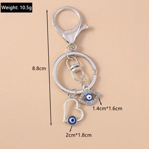 Detail view of silver keychain with devil eye and heart charms including exact dimensions