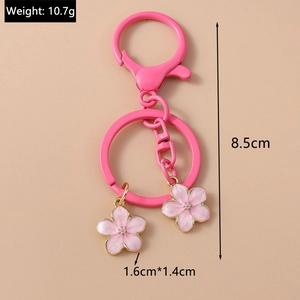 Pink enamel cherry blossom keychain detail showing 10.7g weight and 8.5cm height dimensions