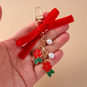 Elegante portachiavi con fiocco in velluto rosso e ciondoli a forma di fiori