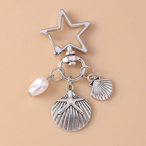 Detailed macro shot of vintage starfish shell keychain with star carabiner and white pearl