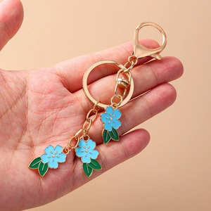 Floral keychain with three light blue cherry blossoms and golden alloy hardware