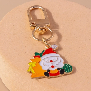 Detail of hand-painted Santa Claus metal keychain with golden lobster clasp and vibrant colors