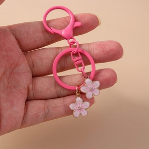 Pink enamel cherry blossom keychain with gold plating and metal hook for backpack