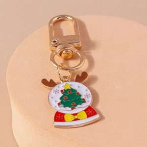 Detail of Christmas tree snow globe keychain with enamel finish and golden metal clasp