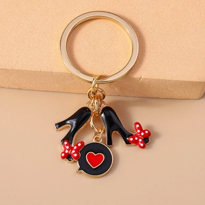 Porte-clés doré chic avec talons hauts noirs, nœuds à pois et pendentif cœur rouge