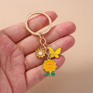 Porte-clés doré avec charms tournesol jaune, marguerite et papillon pour sacs et mobiles