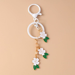 Detailed close-up of cherry blossom keychains with D-ring clasp and three white flower charms