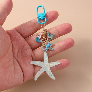 Detail of ocean-themed mermaid keychain with resin starfish and blue metal clip