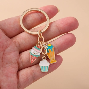 Gros plan du porte-clés doré orné de breloques colorées en forme de glace et cupcake