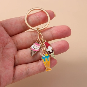 Détail de breloques mignonnes en forme de glace et dessert sur un porte-clé doré
