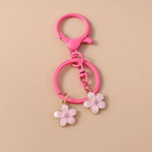 Detail of pink cherry blossom keychain charms with gold edges and pink lobster clasp