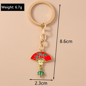 Detail view of a Chinese style fan keychain with red enamel finish and green bamboo motifs