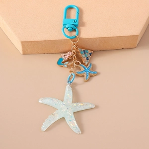 Detail of ocean-themed keychain with starfish mermaid charms and blue carabiner clip