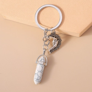 Detailed macro of vintage turquoise moon and hexagonal stone pendant on keychain