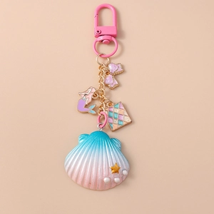 Detail view of ocean-themed keychain with blue shell, mermaid pendant and pink bow