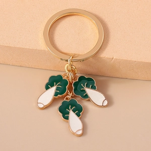 Détails des pendentifs de radis avec feuilles vertes et anneau de clé doré