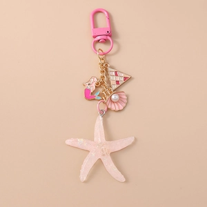 Detailed macro view of pink mermaid keychain with shell, starfish and pearl charms